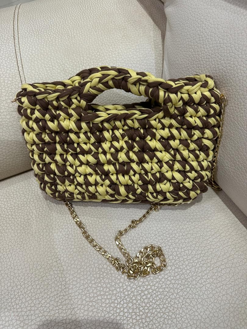 Sac crocheté chiné marron et jaune avec anse et chaîne dorée.
